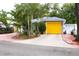 Charming blue home featuring well-manicured landscaping and a bright yellow garage door at 3306 E Chelsea St, Tampa, FL 33610