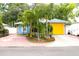 Charming blue home featuring well-manicured landscaping and a bright yellow garage door at 3306 E Chelsea St, Tampa, FL 33610