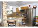Open kitchen featuring a stone breakfast bar, stainless steel fridge, and granite countertops at 3306 E Chelsea St, Tampa, FL 33610