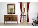 Living Room featuring a mirror, flower display, and interior doorway with burgundy curtains at 3306 E Chelsea St, Tampa, FL 33610
