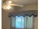 Window with elegant valances and curtains providing soft natural light and privacy to the room at 35209 Dolphin Lake Dr, Zephyrhills, FL 33541