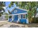 Charming blue home with white trim and a cozy front porch with mature landscaping at 3706 N Ola Ave, Tampa, FL 33603
