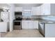 Cozy kitchen with stainless steel appliances, white cabinets, and adjacent laundry area at 3706 N Ola Ave, Tampa, FL 33603