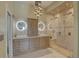 Bathroom with a double sink vanity, lighted mirrors, decorative lighting, and a large glass shower at 413 8Th N Ave, Tierra Verde, FL 33715