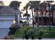 Charming street view with palm trees framing the houses and waterfront in the background at 413 8Th N Ave, Tierra Verde, FL 33715