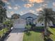 Charming single-Gathering home featuring a well-manicured lawn, mature palms, and an attached two-car garage at 413 8Th N Ave, Tierra Verde, FL 33715