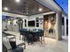 Covered outdoor kitchen with grill, bar, and seating near pool at dusk at 413 8Th N Ave, Tierra Verde, FL 33715