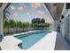 A private swimming pool with a clean white deck, lush greenery, lounge chairs, and a covered area at 413 8Th N Ave, Tierra Verde, FL 33715