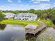 An aerial view of light blue condo buildings with a lakeside gazebo and boardwalk at 4141 Dolphin Dr # 4141, Tampa, FL 33617