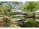 Charming backyard with a quaint bridge over a creek, surrounded by lush greenery and mature trees at 4141 Dolphin Dr # 4141, Tampa, FL 33617