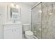 Bright bathroom with white vanity, framed mirror and glass shower enclosure with white marble tile at 4141 Dolphin Dr # 4141, Tampa, FL 33617