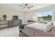 Sunlit bedroom boasts a lake view, stylish furniture, a ceiling fan, and sleek tiled floors at 4141 Dolphin Dr # 4141, Tampa, FL 33617