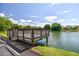 Community dock with lake view and bench seating overlooking lush landscaping and beautiful blue skies at 4141 Dolphin Dr # 4141, Tampa, FL 33617