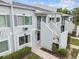 Exterior view of the building with gray paint, white railings and stairs, and well-kept landscaping at 4141 Dolphin Dr # 4141, Tampa, FL 33617