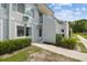 Close view of a two-story condo unit showcasing its clean exterior, balcony and lush landscaping at 4141 Dolphin Dr # 4141, Tampa, FL 33617