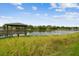 Scenic view of a wooden gazebo on the water, surrounded by lush greenery and a clear blue sky at 4141 Dolphin Dr # 4141, Tampa, FL 33617