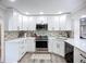 Bright kitchen with white cabinets, stainless steel appliances, and decorative backsplash at 4231 8Th N St, St Petersburg, FL 33703