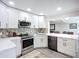 Bright kitchen featuring white cabinets, stainless steel appliances, and unique backsplash tile design at 4231 8Th N St, St Petersburg, FL 33703
