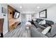 Living room with a large grey sectional, french doors, wood-look floors and wood accent wall at 4231 8Th N St, St Petersburg, FL 33703