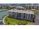 Aerial shot of condo building with ocean views, lush lawns, a dock, and a pool at 425 150Th Ave # 2301, Madeira Beach, FL 33708