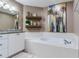 Relaxing bathroom featuring a soaking tub with custom tile surround and granite-topped vanity at 425 150Th Ave # 2301, Madeira Beach, FL 33708