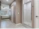 Bathroom with a glass enclosed shower and tile flooring next to the main bedroom at 425 150Th Ave # 2301, Madeira Beach, FL 33708
