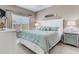 Cozy bedroom featuring a bed with blue bedding, bedside tables, and a bright window at 425 150Th Ave # 2301, Madeira Beach, FL 33708