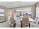 Bright dining area with an open concept to the kitchen featuring a white table and woven chairs at 425 150Th Ave # 2301, Madeira Beach, FL 33708