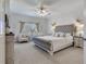 This spacious bedroom boasts an upholstered headboard, ceiling fan and sitting area by the window at 425 150Th Ave # 2301, Madeira Beach, FL 33708