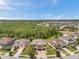 Expansive aerial view showcasing the residential neighborhood, mature trees and lush landscaping at 4419 Ortona Ln, Wesley Chapel, FL 33543