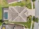Drone's eye view of a home showcasing screened in swimming pool and patio, beautiful landscaping, and tile roof at 4419 Ortona Ln, Wesley Chapel, FL 33543