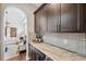 Convenient butler's pantry featuring custom cabinetry, countertops, and access to the living area at 4419 Ortona Ln, Wesley Chapel, FL 33543