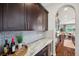 Butler's pantry with dark cabinetry, quartz countertops, tile backsplash, and wine storage at 4419 Ortona Ln, Wesley Chapel, FL 33543