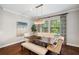 Sunlit dining area with a wood table, upholstered seating, and views of the outdoors at 4419 Ortona Ln, Wesley Chapel, FL 33543