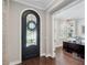 Elegant entryway featuring a wrought-iron door, hardwood floors, and an open view to the home office at 4419 Ortona Ln, Wesley Chapel, FL 33543