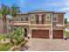 Beautiful two-story home featuring arched entryway, balcony, three-car garage, and mature landscaping at 4419 Ortona Ln, Wesley Chapel, FL 33543
