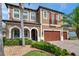 Charming two-story home with a well-manicured front lawn, mature palm trees, and a three-car garage at 4419 Ortona Ln, Wesley Chapel, FL 33543