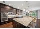 Gourmet kitchen featuring dark wood cabinetry, granite countertops, and a large island at 4419 Ortona Ln, Wesley Chapel, FL 33543