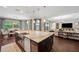 Open-concept kitchen with a large island featuring granite countertops and stainless steel appliances at 4419 Ortona Ln, Wesley Chapel, FL 33543
