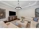 Comfortable living room featuring a sectional sofa and coffered ceilings at 4419 Ortona Ln, Wesley Chapel, FL 33543