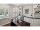 Bright office featuring custom built-ins, plantation shutters, and a dark wood desk at 4419 Ortona Ln, Wesley Chapel, FL 33543