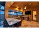 Covered outdoor kitchen featuring a built-in grill, bar seating, a television, and tiled backsplash at 4419 Ortona Ln, Wesley Chapel, FL 33543