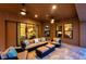Outdoor patio with comfortable seating, ceiling fans, and sliding doors leading to the home's interior at 4419 Ortona Ln, Wesley Chapel, FL 33543
