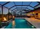 Stunning screened-in pool area with fire features, lounge chairs, and outdoor kitchen, blending luxury and comfort at 4419 Ortona Ln, Wesley Chapel, FL 33543