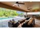 Luxurious screened pool area featuring comfortable outdoor seating, a bar, and an outdoor kitchen at 4419 Ortona Ln, Wesley Chapel, FL 33543