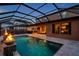 Beautiful screened-in pool with patio, fire feature, and landscaped surroundings, perfect for relaxation and entertainment at 4419 Ortona Ln, Wesley Chapel, FL 33543