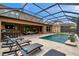 Inviting screened-in pool and patio area with outdoor bar and lounge seating for entertaining at 4419 Ortona Ln, Wesley Chapel, FL 33543