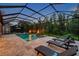 Private screened-in pool area featuring lounge chairs and fire features, perfect for enjoying the outdoors at 4419 Ortona Ln, Wesley Chapel, FL 33543