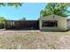 Backyard view with screened in lanai, storage shed, treeline, and building architecture at 4425 W Bay Villa Ave, Tampa, FL 33611