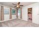 Bedroom with neutral carpet, ceiling fan, and two windows with sheer curtains at 4425 W Bay Villa Ave, Tampa, FL 33611